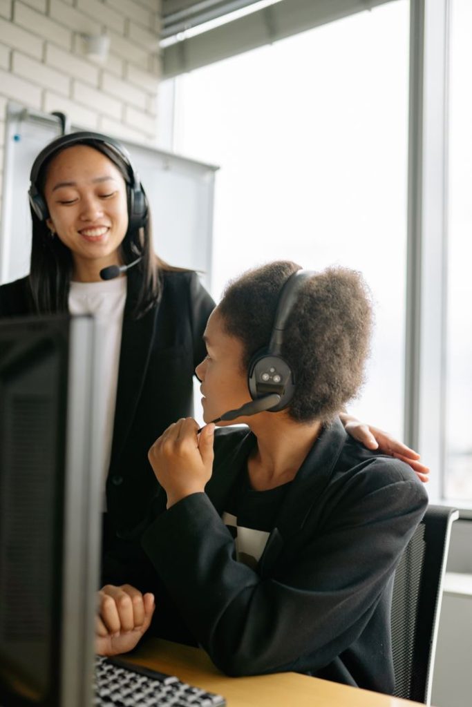 Two call center agents communicating in an office setting, enhancing teamwork.